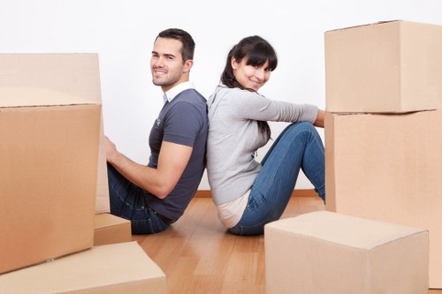 Moving team carrying household items through a Brixton flat staircase
